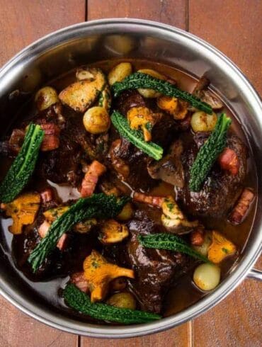 Red wine braised beef cheeks with glazed onions, smoked bacon and wild mushroom